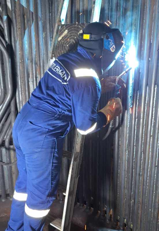 Technician performing boiler tube repair